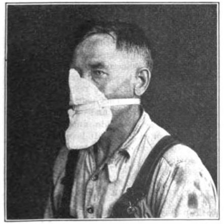 Photo of worker with cloth tied against his mouth and nose